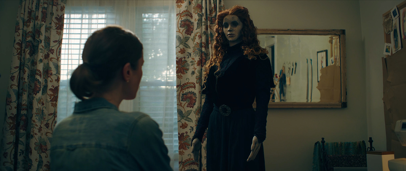 A woman stands in front of a mannequin dressed in a black outfit in 825 Forest Road.